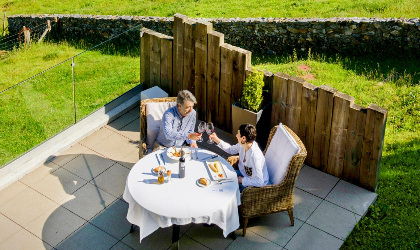 Couple toasting at a meal on a restaurant terrace